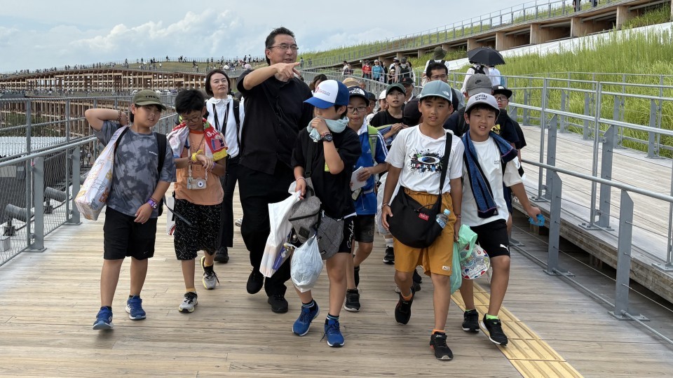 大屋根リングの上を歩く東神楽町の小学生と藤本壮介さん（提供:東神楽町）