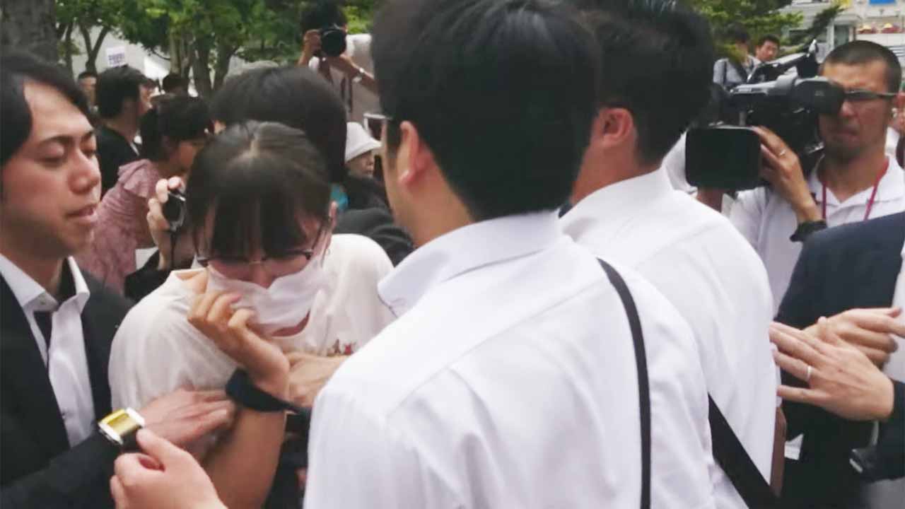 「増税反対」とヤジを飛ばした女性が排除される様子(写真)